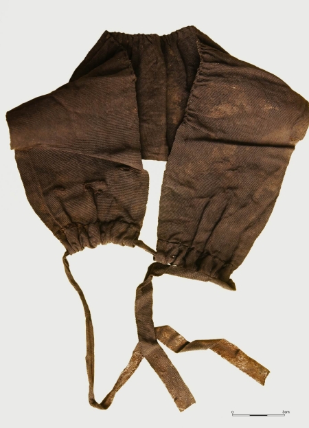Prawdopodobnie jedwabny kołnierzyk nakładany na szyję i ściągany jedwabną tasiemką pod brodą. Nie był przyszyty do sukni, z którą był prawdopodobnie noszony. XVII–XVIII wiek (opr. Jerzy Maik).
