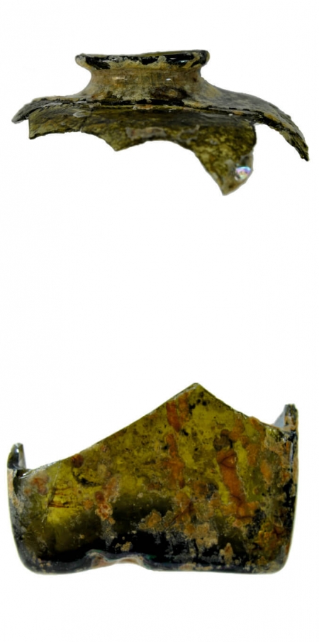 Czworoboczna flaszka z ciemnozielonego szkła zrekonstruowana na podstawie dna na planie prostokąta o bokach 7,3 × 8,5 cm oraz wylewu z krótką szyjką i szerokim ramieniem. XVII wiek (opr. A. Wilgocka)
